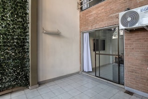 A building with a glass door and a tiled floor, a brick wall, and a BGE air conditioning unit. - Spacious Duplex by Don Julio (Buenos Aires)