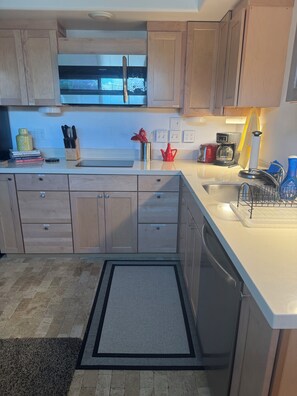 A modern kitchen with wooden cabinets, a stainless steel sink, and a built-in oven. - Palm Desert Retreat with Pool-Furnished 30+ Day Stay (Desert Hot Springs)