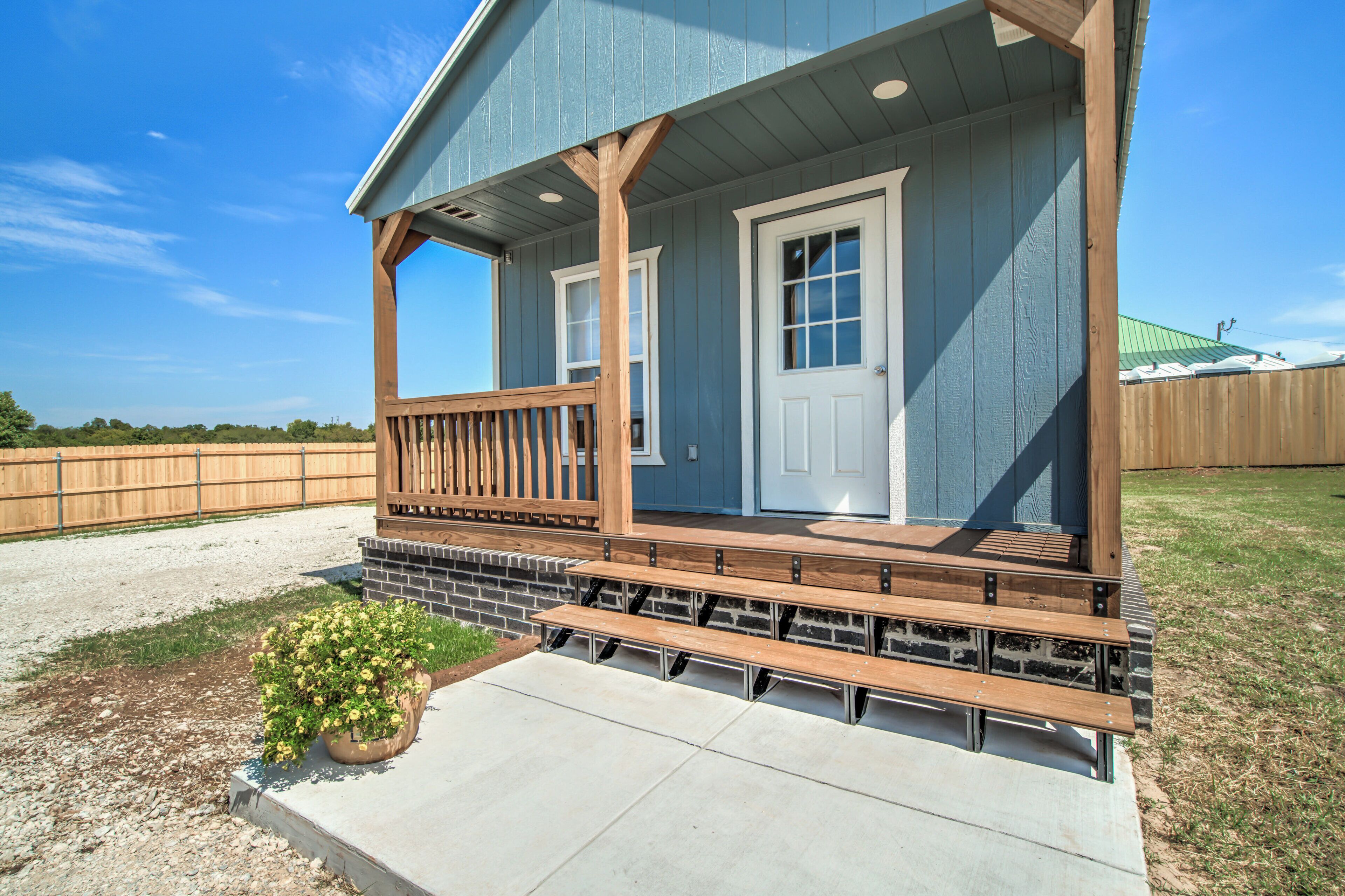 A house with a porch, a front door, and a small garden area with a potted plant.