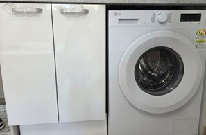 Eine Waschmaschine von LG mit Frontlader, Bedienfeld und Dosierfach für Waschmittel.