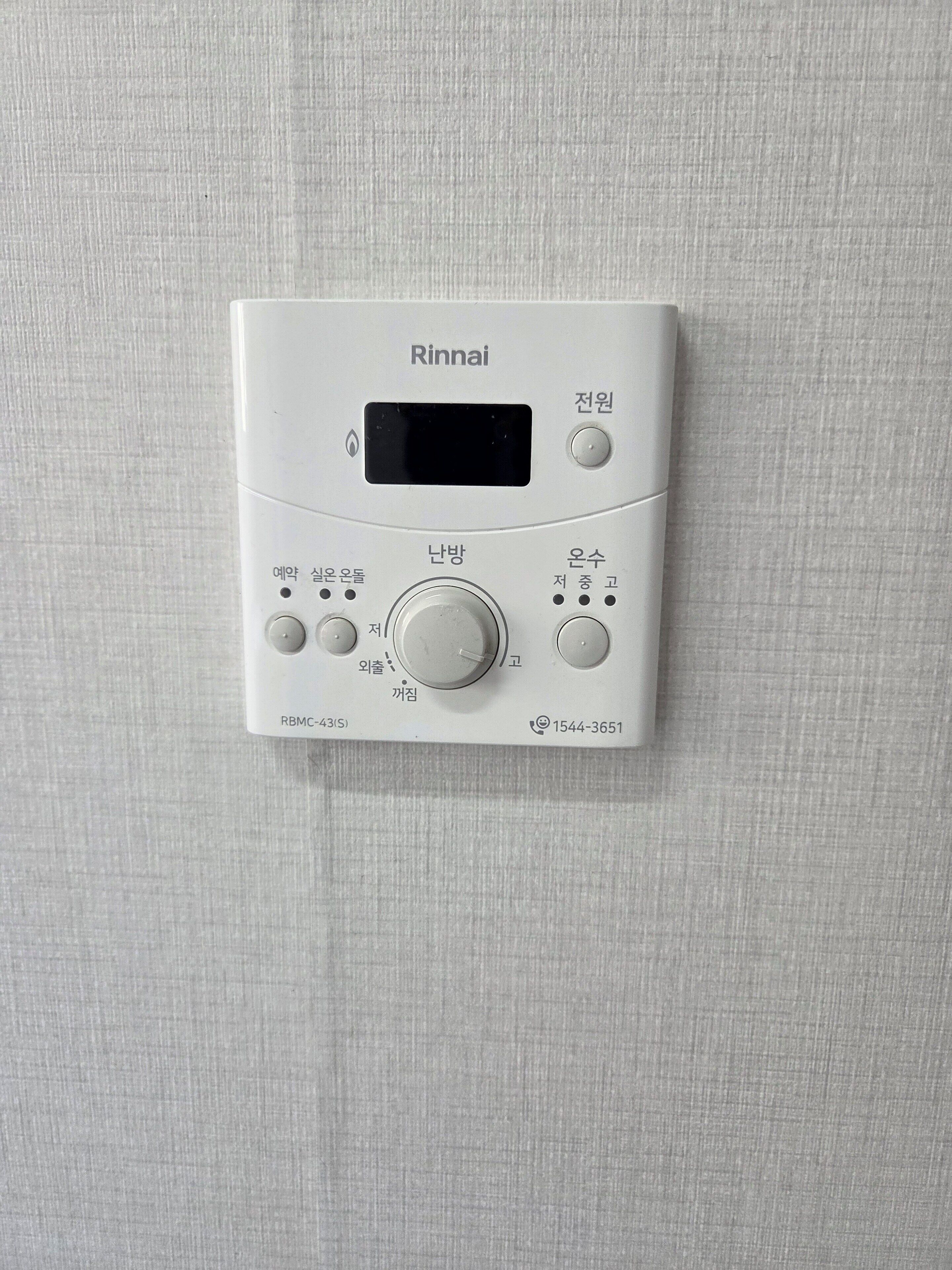 Ein weißer Rinnai-Warmwasserbereiter mit digitaler Anzeige, Bedienelementen und einer Modellnummer.