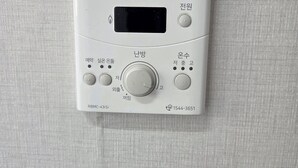 En vit varmvattenberedare från Rinnai med en digital display, justeringsknappar och ett modellnummer.