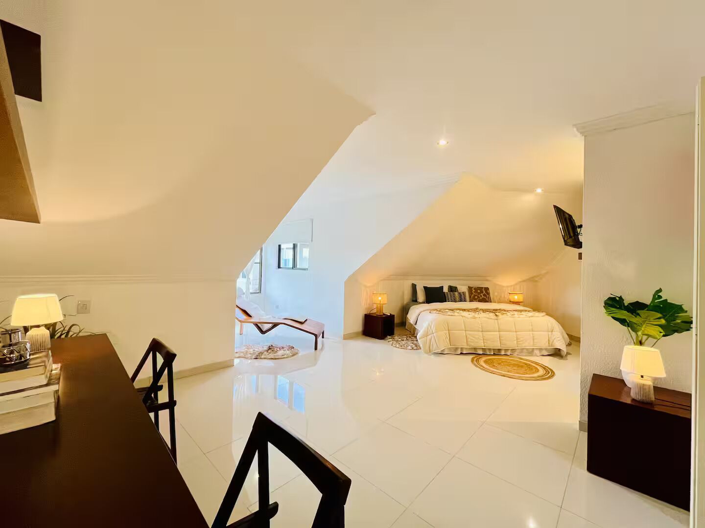 Une chambre à coucher moderne avec un grand lit, un bureau et une chaise.