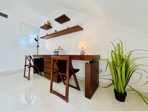 A modern office space with a desk, chairs, a lamp, and a potted plant. - Dúplex Premium - Piscinas, Jacuzzi & Sauna (Santa Cruz de la Sierra)