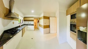 A modern kitchen with a gas stove, oven, and microwave. - Dúplex Premium - Piscinas, Jacuzzi & Sauna (Santa Cruz de la Sierra)