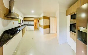 A modern kitchen with a gas stove, oven, and microwave. - Dúplex Premium - Piscinas, Jacuzzi & Sauna (Santa Cruz de la Sierra)