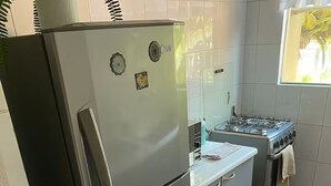 A compact kitchen with a refrigerator, stove, and oven.