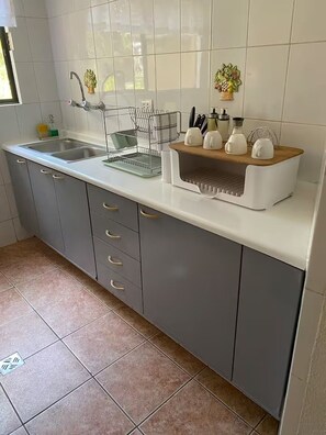 A kitchen with a sink, a dish rack, and a wooden countertop with kitchen utensils. - Spa Retreat - Sauna + Resort Style Amenities (Santa Cruz de la Sierra)