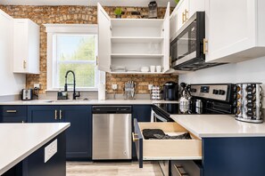 A modern kitchen with a dishwasher, stove, and coffee maker. - Salt Lake City Comfort! 1 Bed 1 Bath (Salt Lake City)