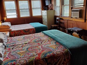 A room with two beds, a dresser, a chair, and a window with blinds. - Goodyear Lake Boathouse - charming historic cottage overlooking the water (Oneonta)