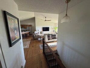 A spacious living area with a kitchen, a dining area, and a staircase leading to an upper floor.