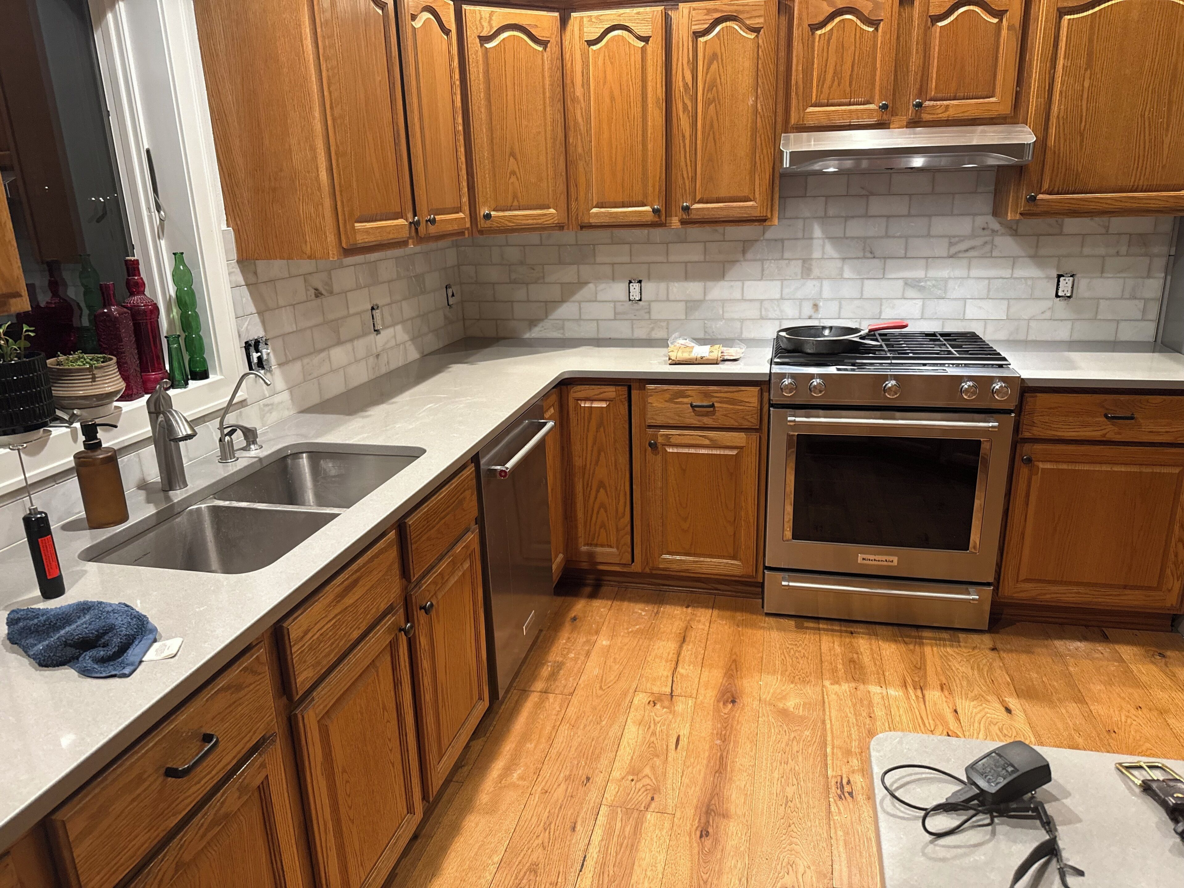 A kitchen with wooden cabinets, a stainless steel sink, and a built-in oven.