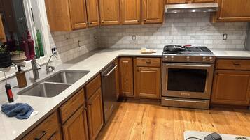A kitchen with wooden cabinets, a stainless steel sink, and a built-in oven.
