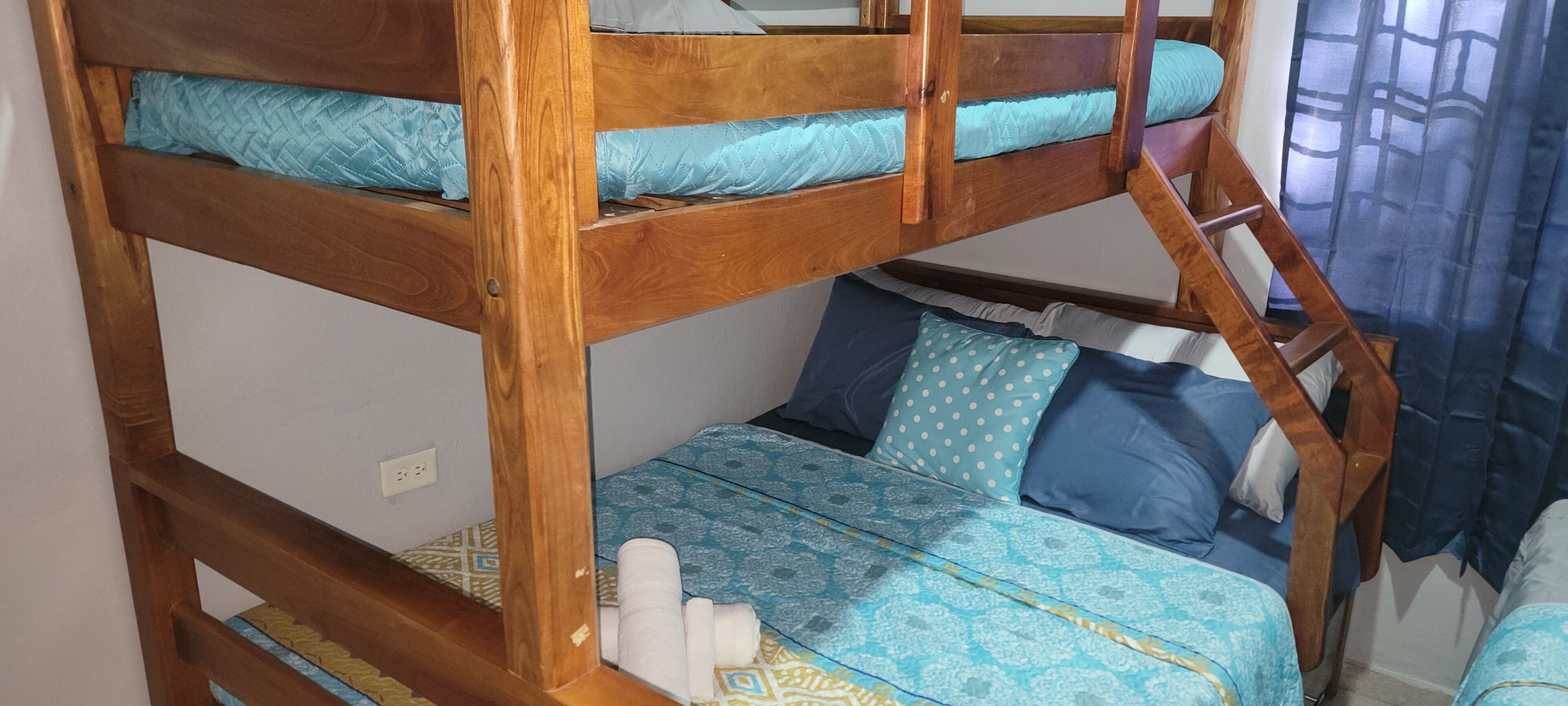 Een stapelbed met een onderbed en een matras met beddengoed met een patroon.
