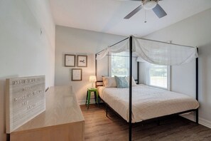 A bedroom with a four-poster bed, a nightstand, a lamp, and framed artwork on the wall. - ↬Picasso`s Bungalow Triple King Beds Nxt ② Dwntwn↫ (Tampa)