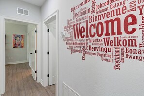Un pasillo con una pared que muestra un gran letrero de bienvenida en varios idiomas.