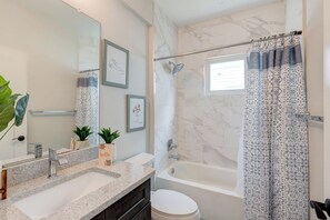 A bathroom with a marble shower, a bathtub, a sink with a mirror, and framed artwork on the wall. - ↬Picasso`s Bungalow Triple King Beds Nxt ② Dwntwn↫ (Tampa)