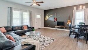 Ein Wohnzimmer mit Sofa, Couchtisch und einem Essbereich mit Stühlen und Tisch.