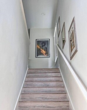 Eine Treppe mit Holzboden und gerahmten Bildern an den Wänden.