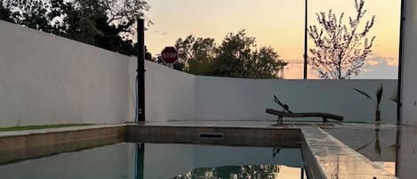 A swimming pool with a stop sign and a sculpture in the background.