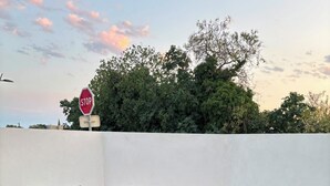 Zwei Liegestühle auf Kunstrasen, im Hintergrund ein Stoppschild und Bäume.