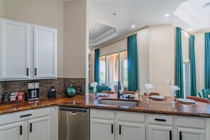 A kitchen with white cabinets, a dishwasher, and a coffee maker. - TPC Golf Condo/Patio/Golf Course View/Sleeps 8/Community Pool/Hot Tub (Scottsdale)