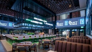 En inomhusrestaurang med olika typer av sittplatser, inklusive bås och bord, samt en bardisk.