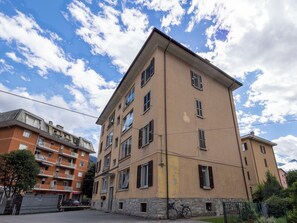 A multi-story residential building with balconies and a paved ground floor. - Genzianella Alpine Apartment by Interhome (Chiavenna)