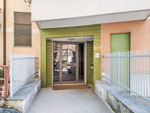 A building entrance with a green tiled facade, a metal gate, and a number '26' sign. - Attico Alda by Interhome (Rapallo)