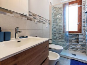 Un baño con ducha, inodoro y lavamanos.