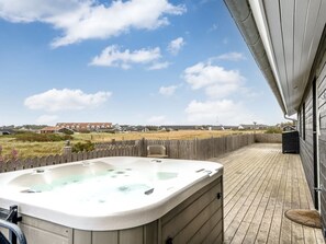 A hot tub on a wooden deck with a view of houses and a fence in the background. - "Arsi" - 350m from the sea by Interhome (Thisted)