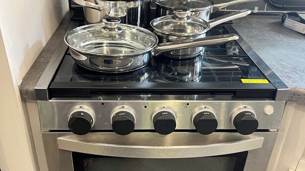 A kitchen with a stove, oven, and pots. - 2-bedroom recreational vehicle in beautiful Shingleton with AC (Shingleton)