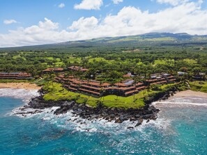 A coastal resort with multiple buildings, a beach, and a rocky shoreline. - Newly Remodeled/Refurnished Oceanfront Makena Surf Condo - Ground Floor (Kihei)