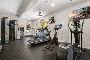 Un gimnasio con equipo de cardio, cintas de correr, elípticas y bicicletas estáticas.