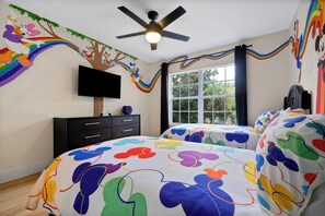 A bedroom with a bed, a TV, a ceiling fan, and a window. - Windsor Hills 5BR/5BA | Pool & Spa, Game Room, 2 Miles to Disney, Themed (Kissimmee)