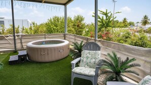 A rooftop terrace with a hot tub, a chair, and a small table. - Private Jacuzzi • Rooftop Escape • Ponce (Ponce)