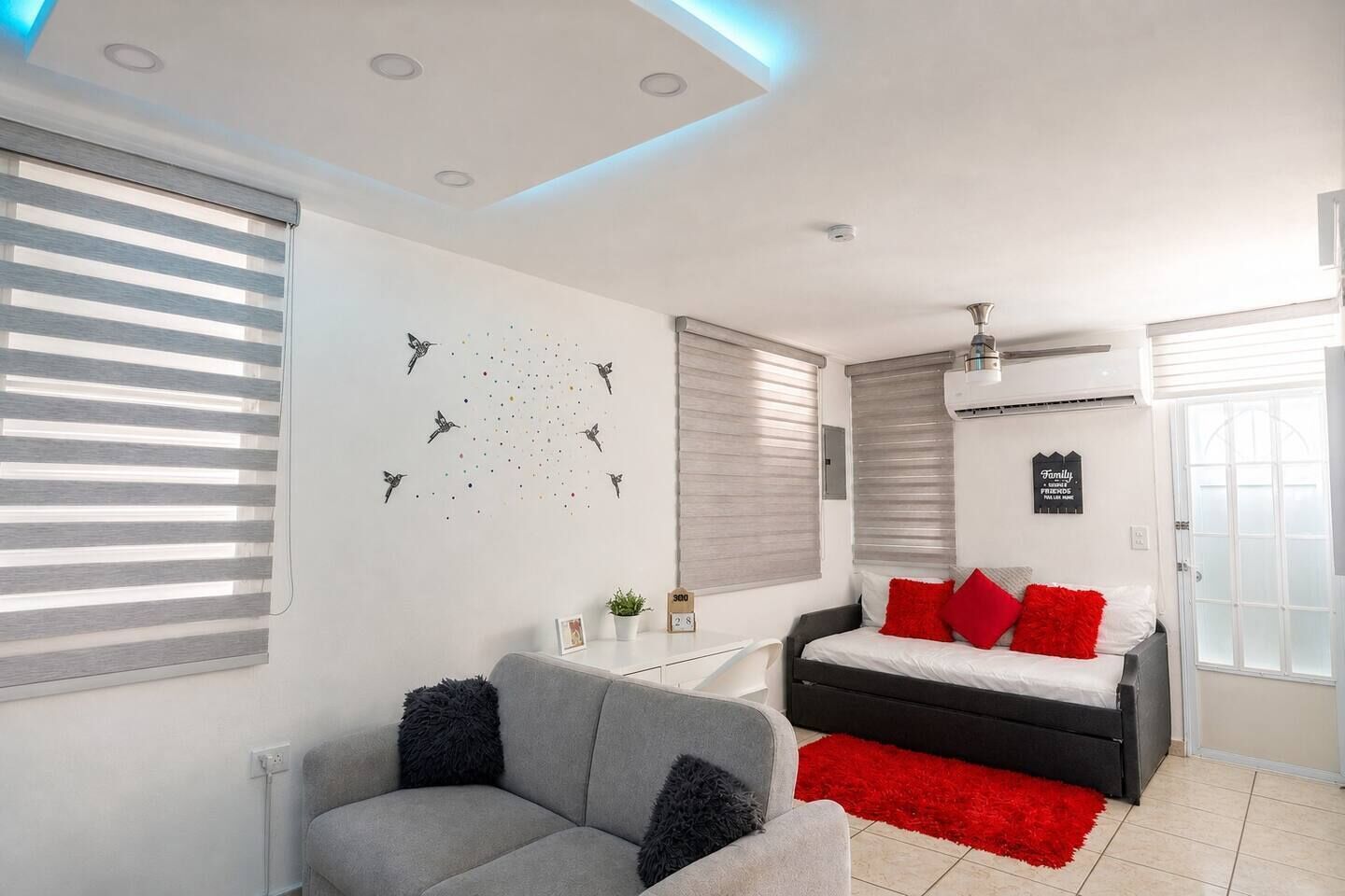 Ein modernes Schlafzimmer mit einem Bett, einer Couch und einem Wandbild.