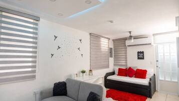 Ein modernes Schlafzimmer mit einem Bett, einer Couch und einem Wandbild.