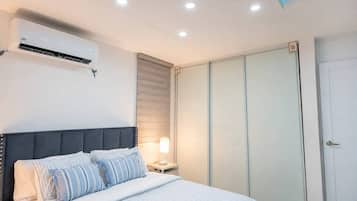 Ein Schlafzimmer mit Bett, Nachttischlampe, Klimaanlage und einem Kleiderschrank.