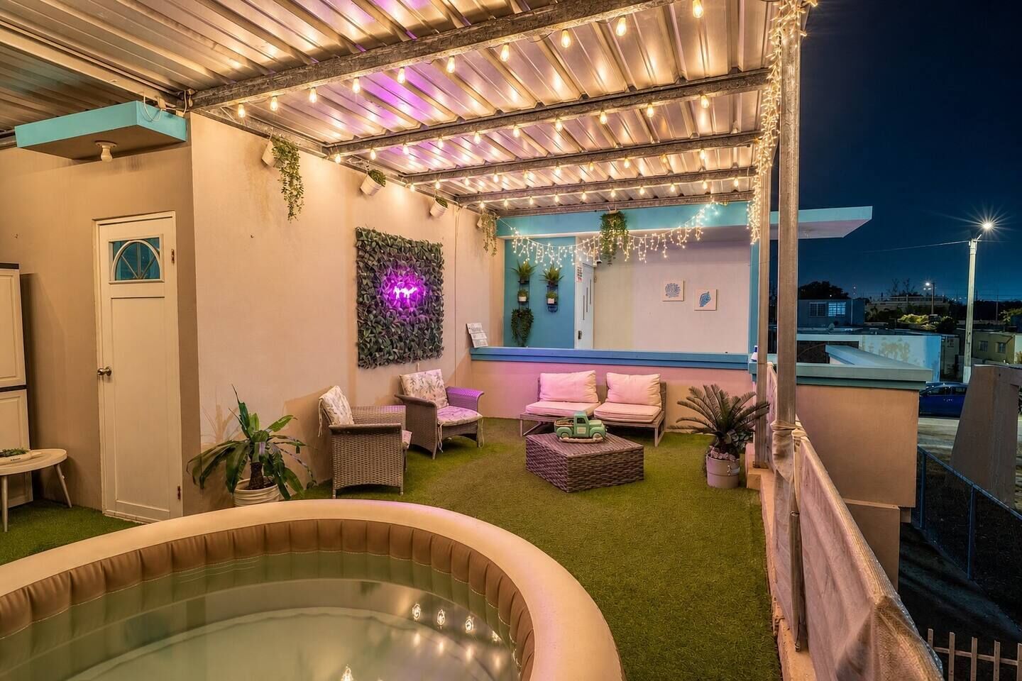 Terraza en la azotea con jacuzzi, zona de estar e iluminación con luces colgantes.