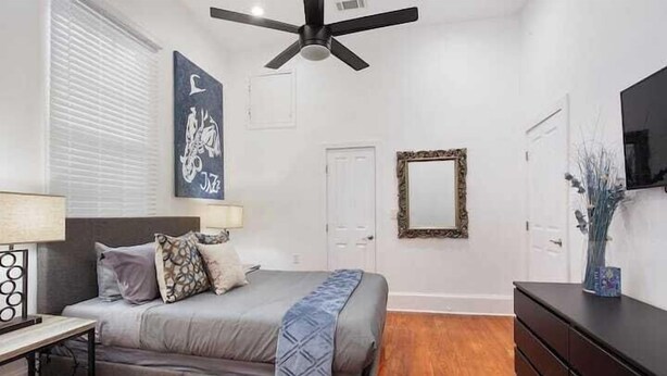 A bedroom with a bed, bedside table, lamp, ceiling fan, and a dresser. - Spacious 4-Bed NOLA Home, Pet-Friendly (New Orleans)
