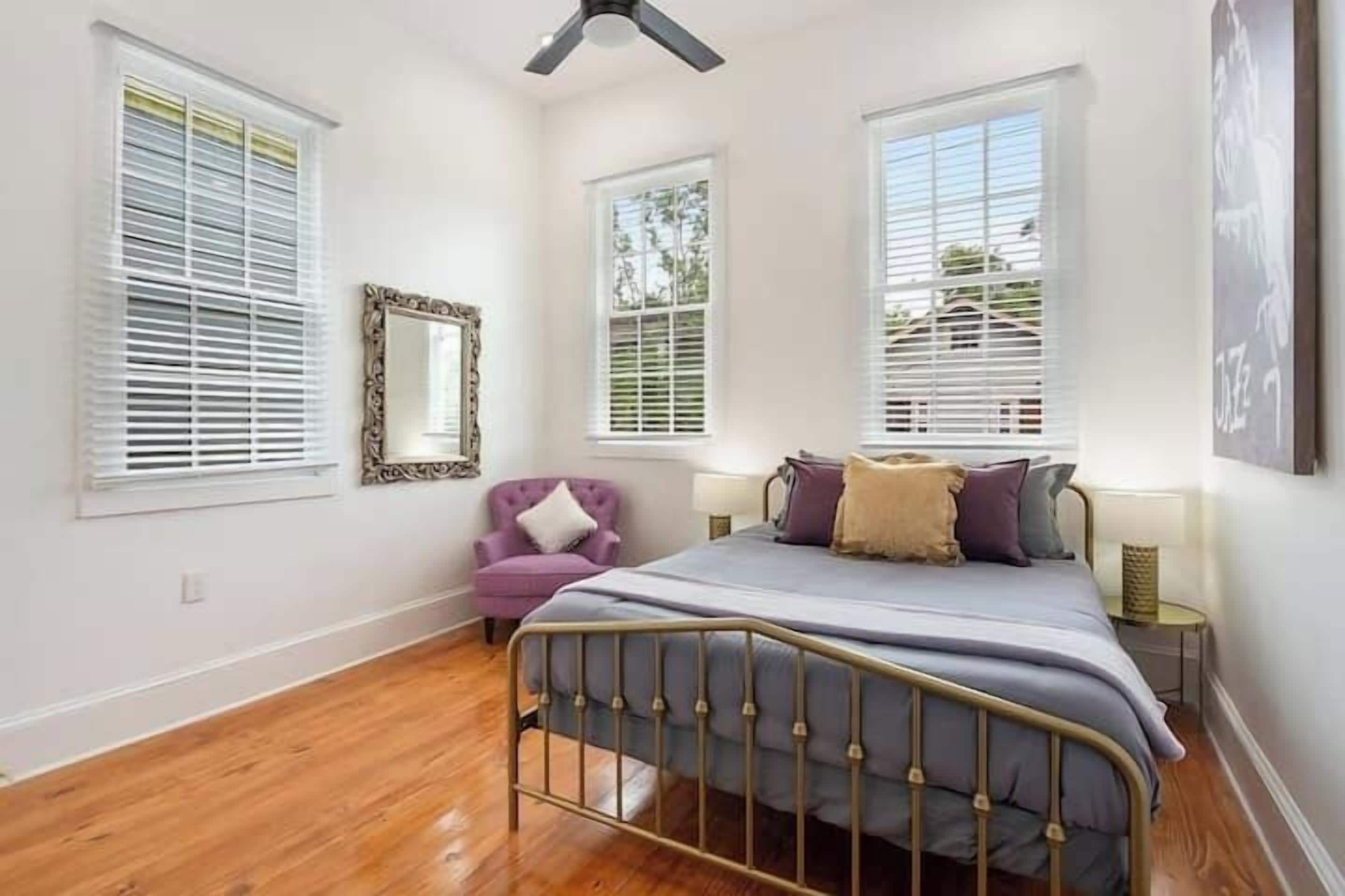 Une chambre à coucher avec un lit, une chaise et un ventilateur de plafond.