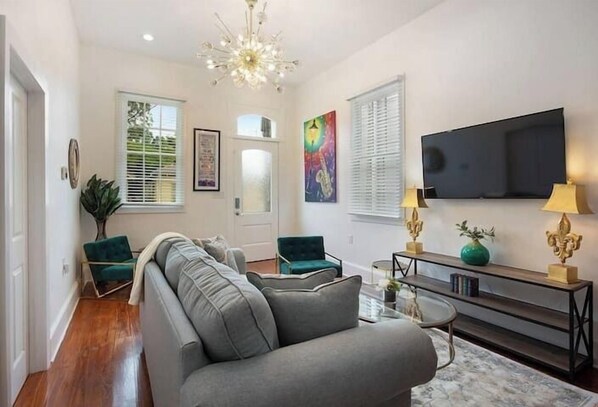 Bright living room with comfortable seating, Smart TV, hardwood floors, and plenty of natural light. - Spacious 4-Bed NOLA Home, Pet-Friendly (New Orleans)