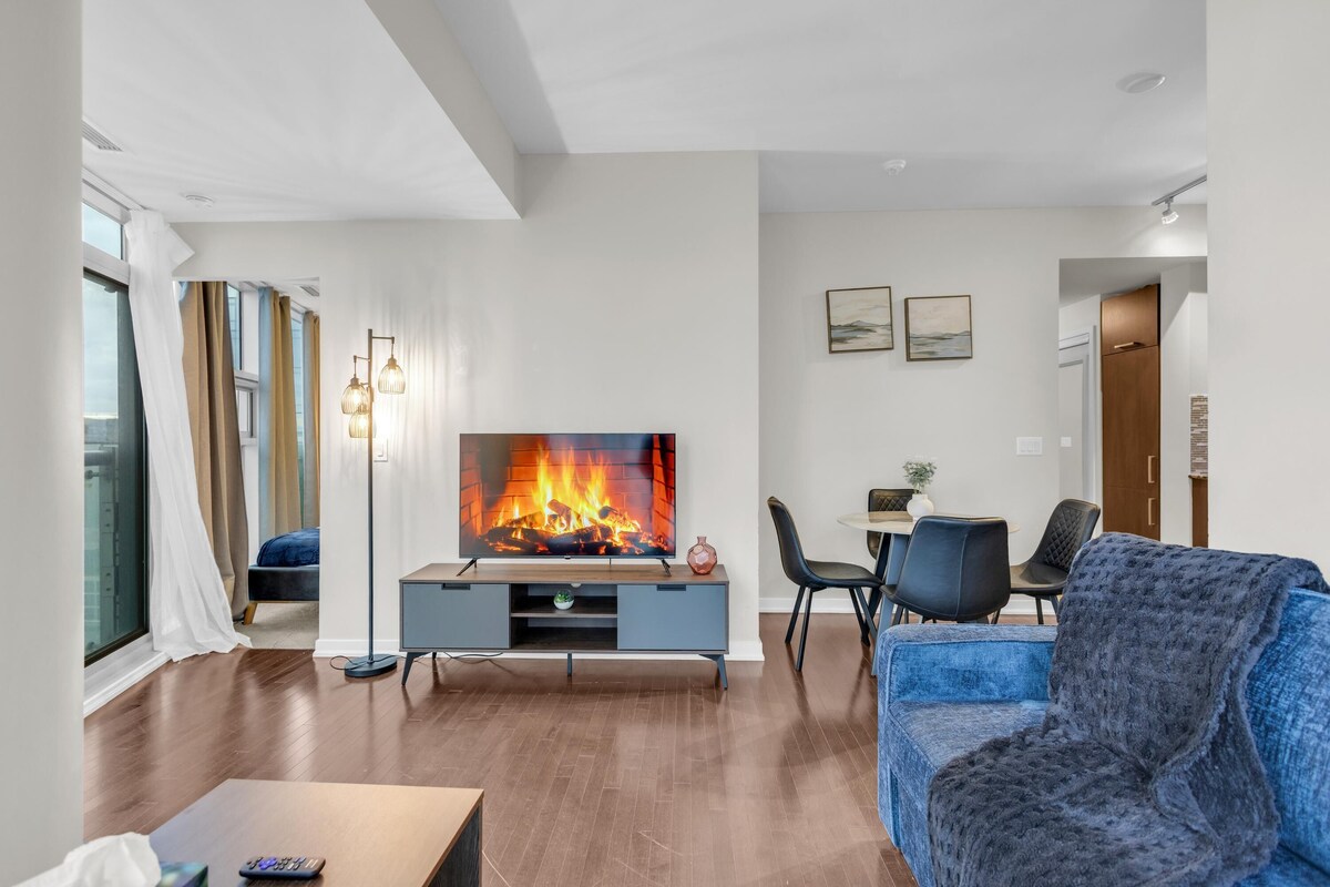Una sala de estar moderna con un televisor de pantalla plana, un sofá azul y una mesa de centro de madera.