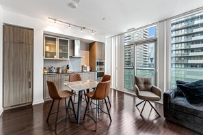 Una cocina moderna con comedor, ventanas amplias y vistas a un paisaje urbano.