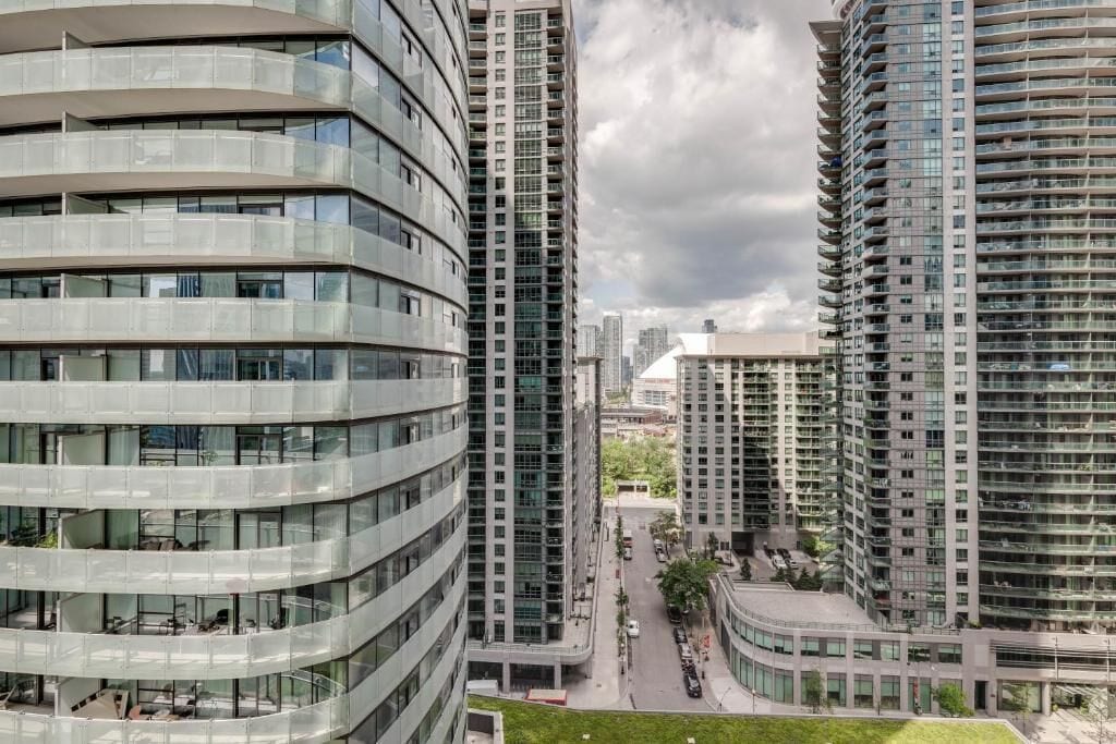 A modern high-rise building with multiple balconies and a curved facade.