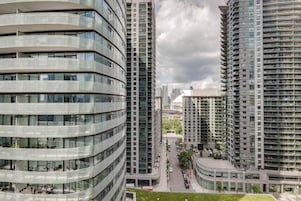 A modern high-rise building with multiple balconies and a curved facade.