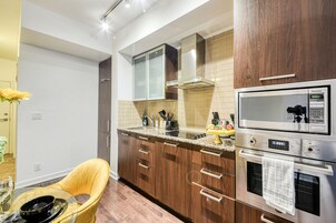 Een moderne keuken met houten kastjes, een roestvrijstalen oven en een ingebouwde magnetron.