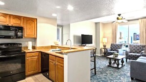 A compact living space with a kitchenette, a dining area, and a seating area with a view.