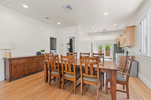A spacious kitchen with wooden cabinets, a dining table with chairs, and a view of the outdoors.